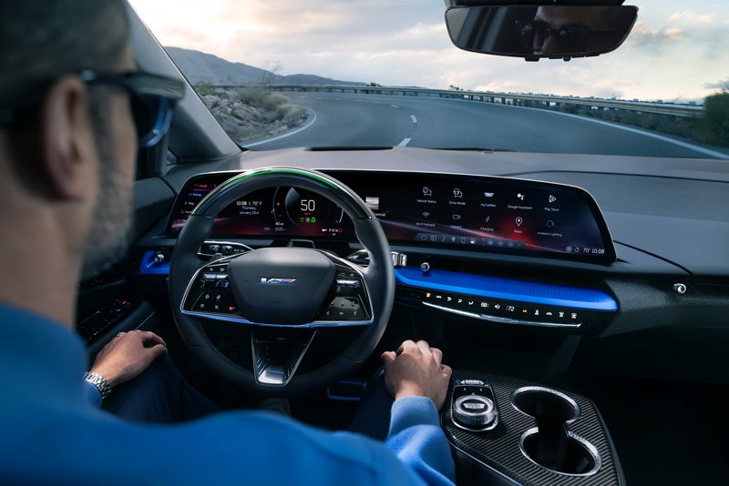 Front View of the 2026 OPTIQ-V Driving Through the Dusk Utilizing its Headlights | Baldwin Cadillac in POPLAR BLUFF MO